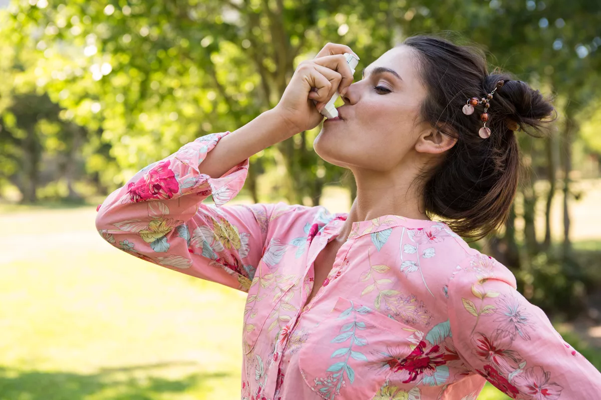 pretty-brunette-using-her-inhaler-on-a-summers-day-2021-08-28-16-39-00-utc